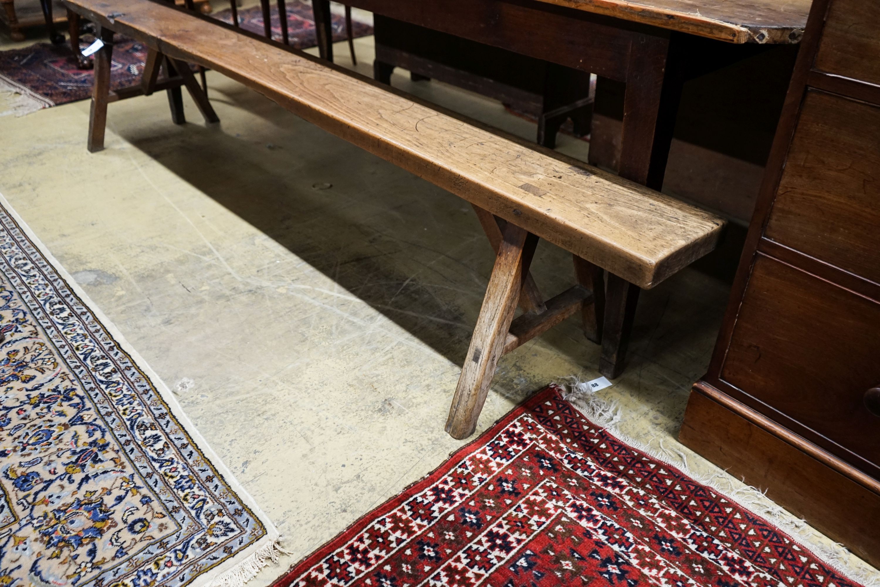 A 19th century French provincial cherry bench seat, length 242cm, depth 46cm, height 46cm